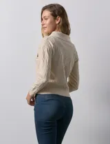 Cardigan color beige en tejido jacquard, con cuello con solapa y abertura central con cierre. Delantera con bolsillos simulados.