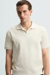 Polo azul marino de punto con textura acanalada vertical, corte regular fit, cuello solapa con abertura frontal y mangas cortas.