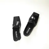 Mocasines negros de charol con punta cuadrada y detalle de antifaz.