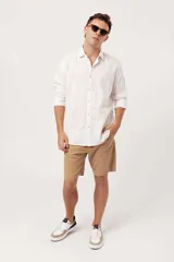 Camisa blanca de lino con estampado de puntos, corte slim fit, manga larga y cuello clásico.