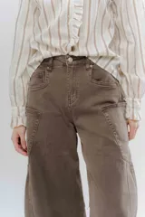 Jean wide leg color marrón, con corte recto y amplio, y costuras protagonistas que crean un diseño geométrico en las piernas.