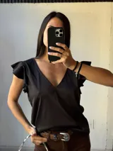 Musculosa negra con escote en V y volados en los hombros.
