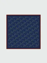 Pañuelo de seda azul marino con estampado de conejos en blanco y borde marrón.