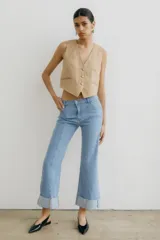Pantalón de jean celeste con corte acampanado y dobladillo en el ruedo.