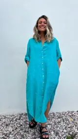 Vestido camisero largo color verde agua, confeccionado en lino 100%, con cuello camisero, abotonadura frontal completa, mangas 3/4 con trabilla y bolsillos laterales.