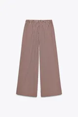 Pantalón de tiro medio con cintura elástica y bolsillos laterales ocultos en costura. Pierna ancha y estampado a rayas verticales color borgoña y blanco.