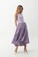 Vestido midi color lila, con cuerpo superior ajustado de punto canalé y falda amplia de tres niveles con textura arrugada.