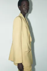 Blazer amarillo mostaza de cuello solapa y manga larga. Cierre frontal cruzado con botones forrados y bolsillos con solapa en delantero.