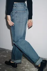Jeans de mujer tiro medio, corte ancho (baggy) y pierna recta, con efecto lavado azul claro. Presenta cinco bolsillos y bajo acabado con vuelta ancha.