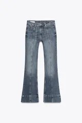 Pantalón de jean azul de tiro alto con nervio marcado delantero, bolsillos delanteros y traseros, bajo acampanado y cierre frontal con cremallera y botón.