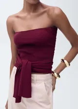Top bandeau color borgoña de tejido de punto fino, sin mangas, con detalle de nudo en la cintura y diseño entallado.