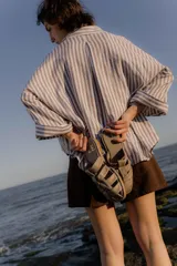 Sandalias tipo mule de cuero color marrón chocolate, con diseño de tiras anchas cruzadas y suela plana.