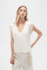 Blusa sin mangas de lino y viscosa, color blanco con laterales en beige, corte holgado y cuello en V.