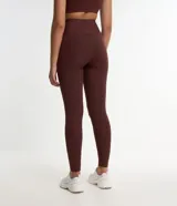 Conjunto deportivo color marrón compuesto por un top de breteles anchos y calzas largas de cintura alta.