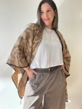 Ruana abierta con estampado animal print en tonos verde y beige, con terminación de crochet negro en los bordes.