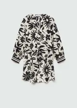 Blusa blanca con estampado floral negro, de tejido fluido, cuello de tira y cierre de lazo.