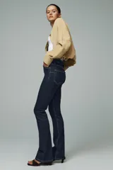 Pantalón de jean azul oscuro, de corte bootcut, tiro alto y cinco bolsillos.