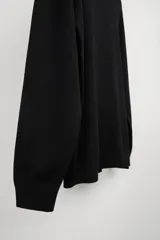 Jersey negro de punto fino con cuello alto y manga larga.