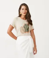 Remera de viscosa color beige con estampado abstracto y bordado de hojas en el frente. Modelo de manga corta y cuello redondo.