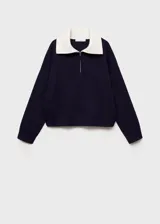 Jersey de punto fino color azul marino con cuello polo blanco y cierre de cremallera.