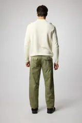 Sweater de tejido de punto color crudo, con cuello polo, cierre frontal con cremallera y mangas largas.