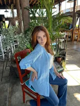 Camisa celeste a rayas verticales blancas, de algodón baumwolle, con cuello camisero, mangas largas con puños abotonados y cierre frontal con botones.