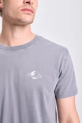 Remera de manga corta color gris con efecto lavado, con estampado en la espalda que incluye una galaxia espiral y texto que dice "Create your own" y "/// GALAXY".