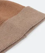 Gorro de lana acrílica color marrón con pompón de piel sintética en la parte superior y dobladillo acanalado.