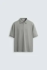 Polo gris de manga corta con cuello solapa y cierre frontal de cremallera.