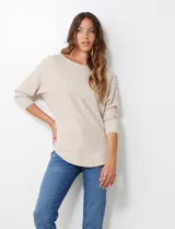 Buzo de tejido rib color beige, con cuello redondo y mangas japonesas de largo tres cuartos.