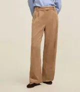 Pantalón recto de cintura alta, confeccionado en terciopelo cotelé color beige, con trabillas en la cintura, cierre tradicional y bolsillos delanteros.