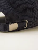 Gorra de béisbol azul de pana con visera curva y orificios de ventilación bordados.