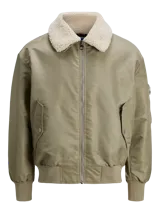 Campera bomber color verde oliva, de manga larga y cuello extendido. Tiene puños ribeteados, cierre con cremallera, bolsillo en la manga y bolsillos frontales con cierre de botón.