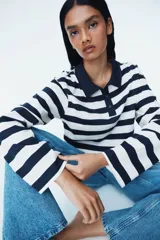 Remera polo de manga larga con cuello clásico y tapeta de botones. Diseño a rayas horizontales blancas y azul marino.