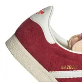 Championes Adidas Gazelle de gamuza color rojo con las tres tiras laterales blancas y suela color crema.