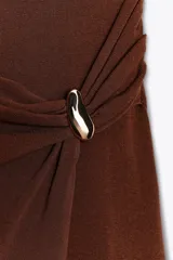 Falda midi color marrón de punto con cintura elástica y corte cruzado. Aplique metálico dorado en la parte delantera.