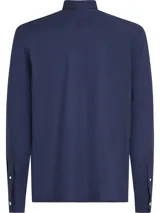 Camisa Tommy Hilfiger de corte slim fit, color azul marino, confeccionada en tejido dobby de algodón con tecnología Flex. Tiene cuello abotonado, manga larga y logo bordado en el pecho.