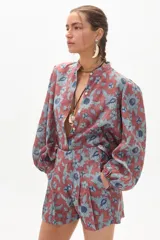 Camisa de lino color ladrillo con estampado de flores azules, cuello mao, mangas largas abullonadas con puño elástico y corte holgado.