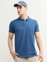 Chomba azul con estampado de pequeños puntos blancos, cuello clásico y mangas cortas.