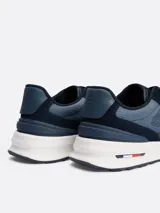 Zapatillas urbanas Tommy Hilfiger modelo Classics, color azul marino con detalles en azul acero. Confeccionadas en cuero y tela, con suela de goma blanca y logo de la marca en el lateral.