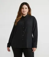 Camisa de mujer de crepe color negro, con cuello solapa, cierre frontal con botones dorados y mangas largas.