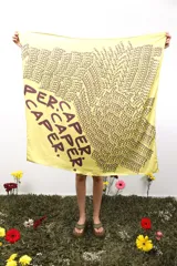 Pañuelo cuadrado amarillo con estampado de la palabra "CAPER" en marrón.