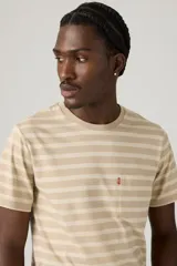 Remera de manga corta a rayas horizontales color beige y blanco, con bolsillo en el pecho y logo de la marca bordado en rojo.