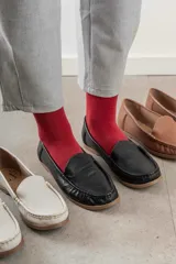 Mocasines de cuero color marrón claro con costuras a la vista.