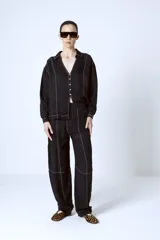 Pantalón negro de corte recto con costuras blancas a contraste.