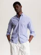 Camisa celeste de corte regular Tommy Hilfiger, confeccionada en algodón Oxford con microestampado de puntos azules. Tiene cuello abotonado, manga larga y logo bordado en el pecho.