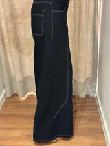 Pantalón ancho de denim con diseño patchwork en diferentes tonos de azul, con tiro alto, corte holgado y cierre frontal con botones.