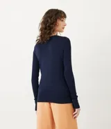 Suéter de punto color verde, con cuello barco, mangas largas y textura acanalada.