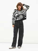 Sweater de punto con estampado abstracto de cebra en blanco y negro, de corte holgado y cuello redondo.