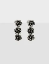 Aros colgantes largos plateados con tres flores y strass.